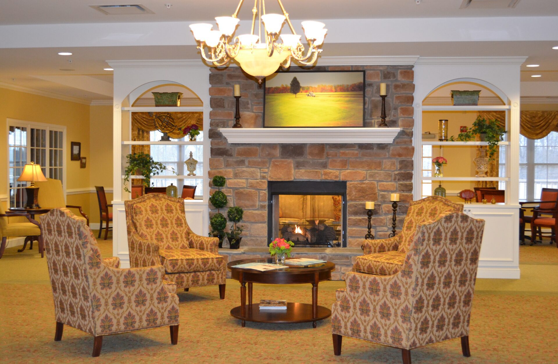 a living room with a fireplace and chairs