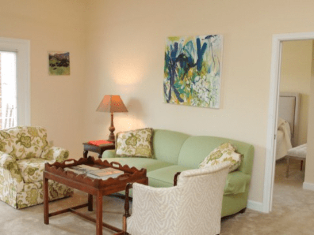 a living room with a green couch and chairs